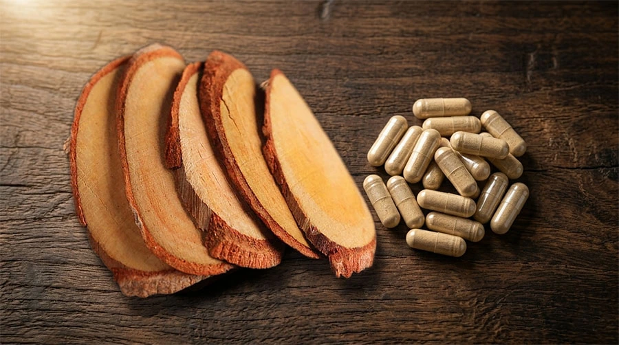 Raw Tongkat Ali root slices on the left alongside supplement capsules on the right, photographed on a wooden surface